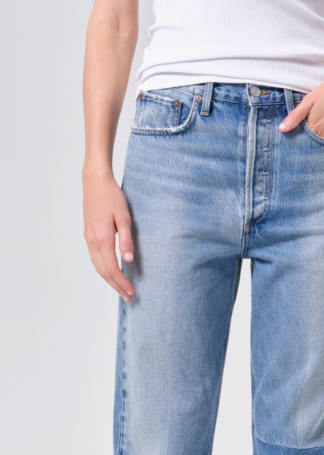 Light blue jeans worn by a person on a plain background
