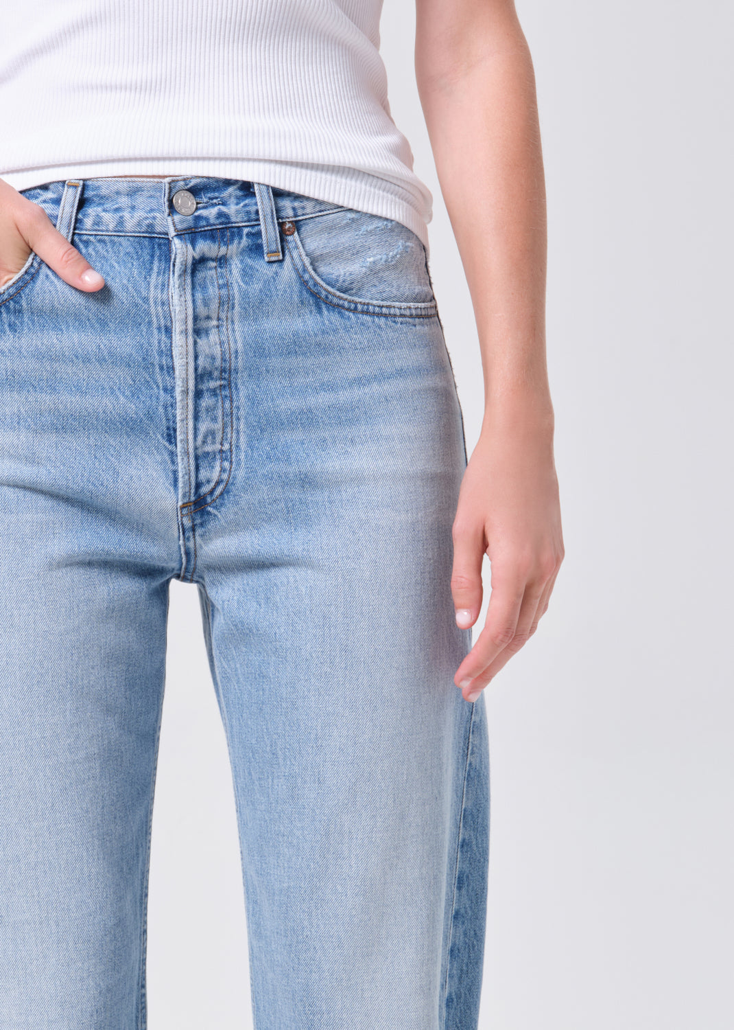 Light blue jeans worn by a person on a white background