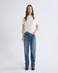 Woman wearing a white t-shirt and blue jeans on a white background