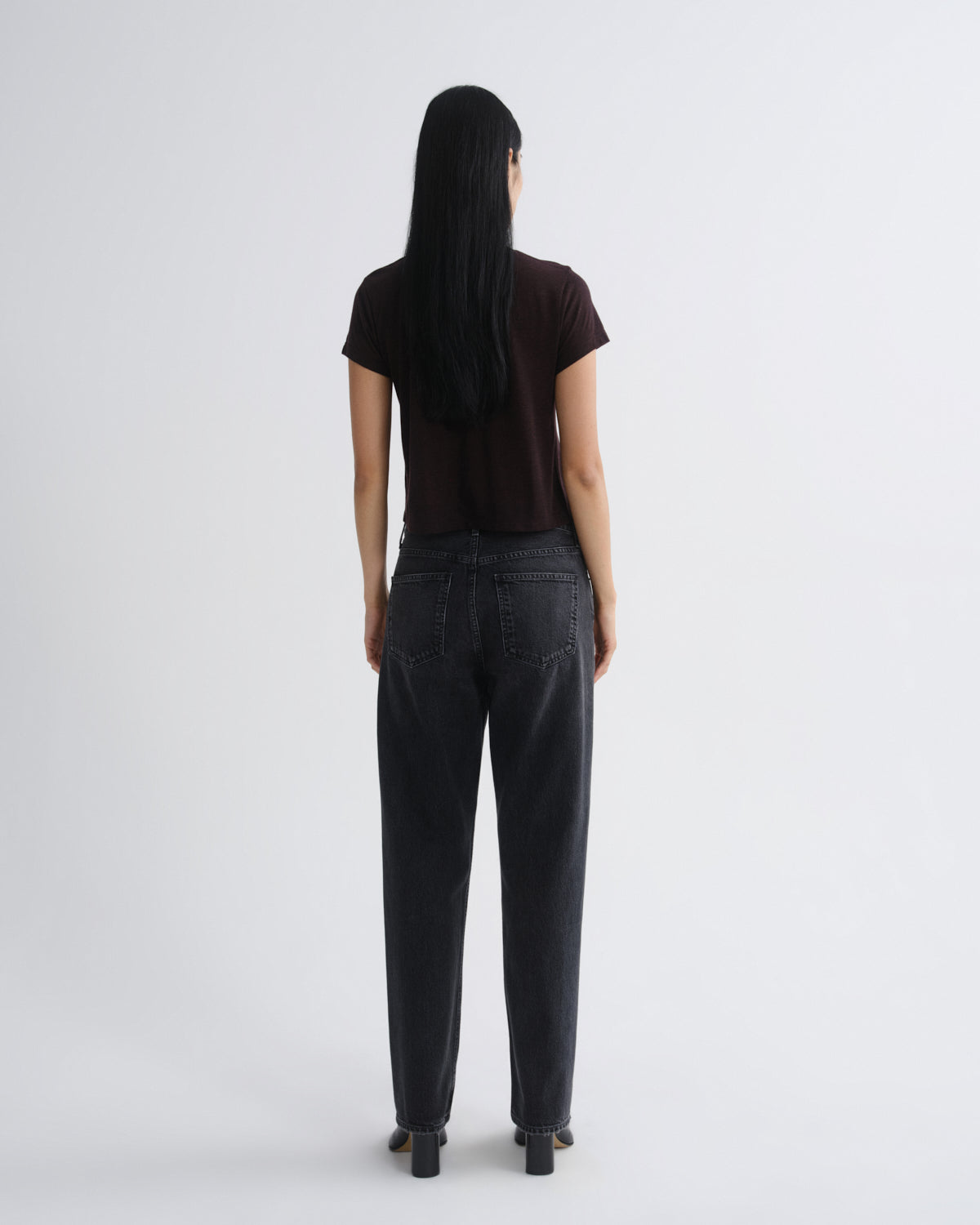 Person wearing black pants and a black top on a white background