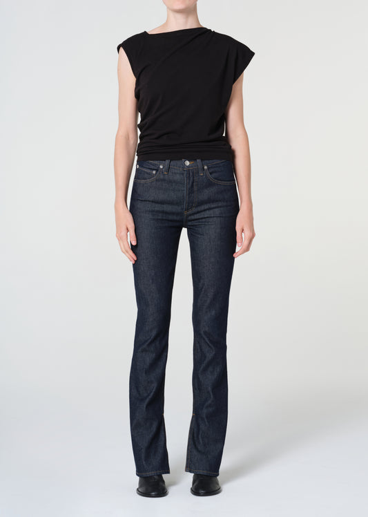 Person wearing a black top and dark blue jeans on a white background