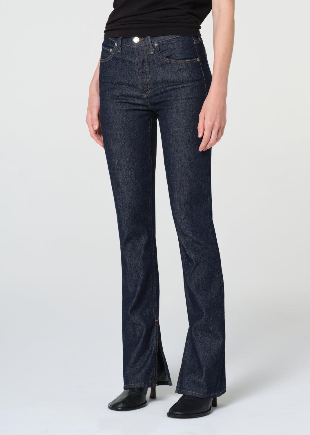 Dark blue jeans worn by a person on a white background