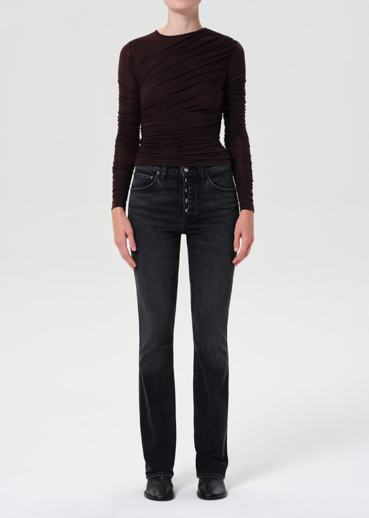 Person wearing a brown ribbed sweater and black jeans on a white background