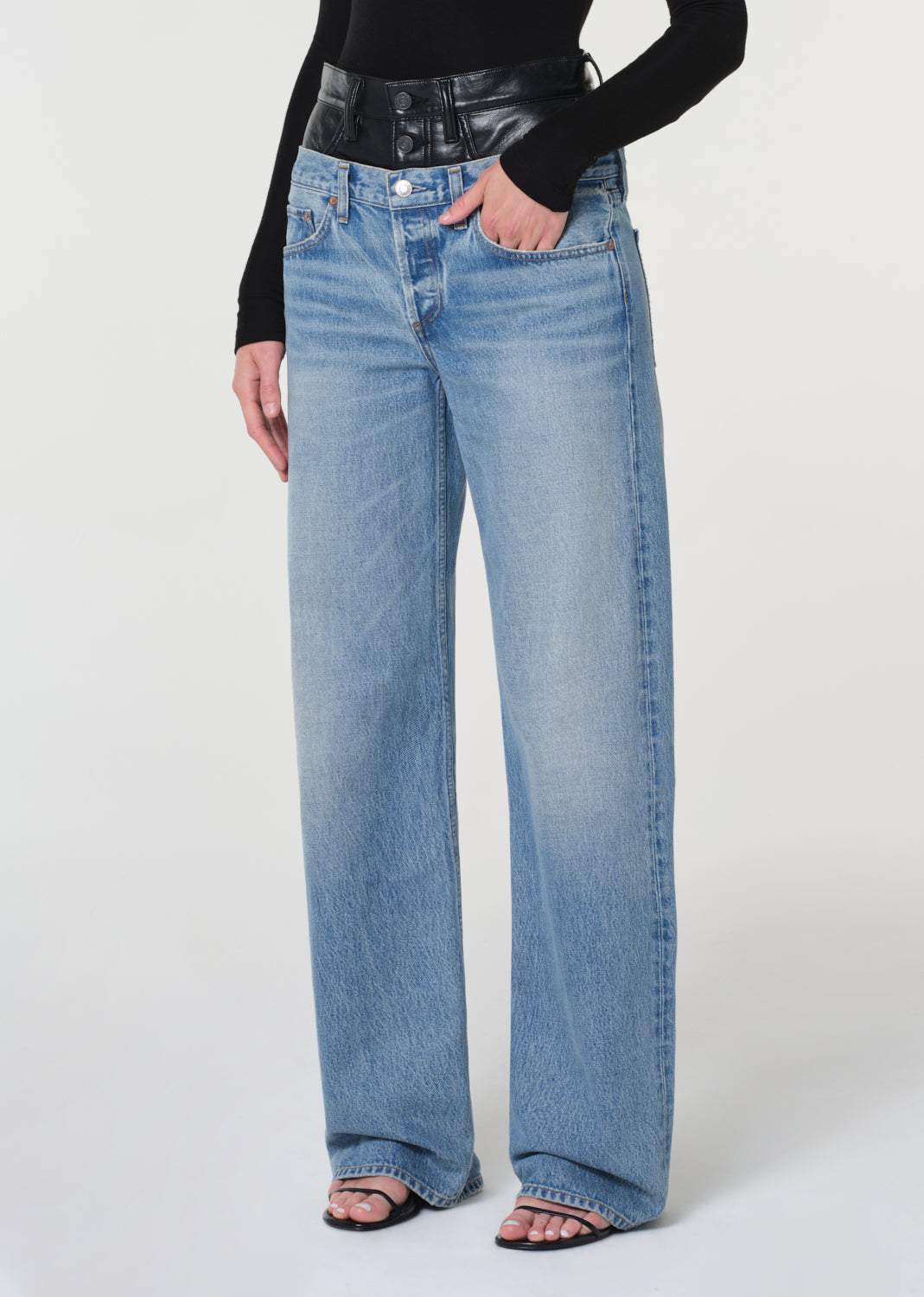 Person wearing light blue jeans on a white background