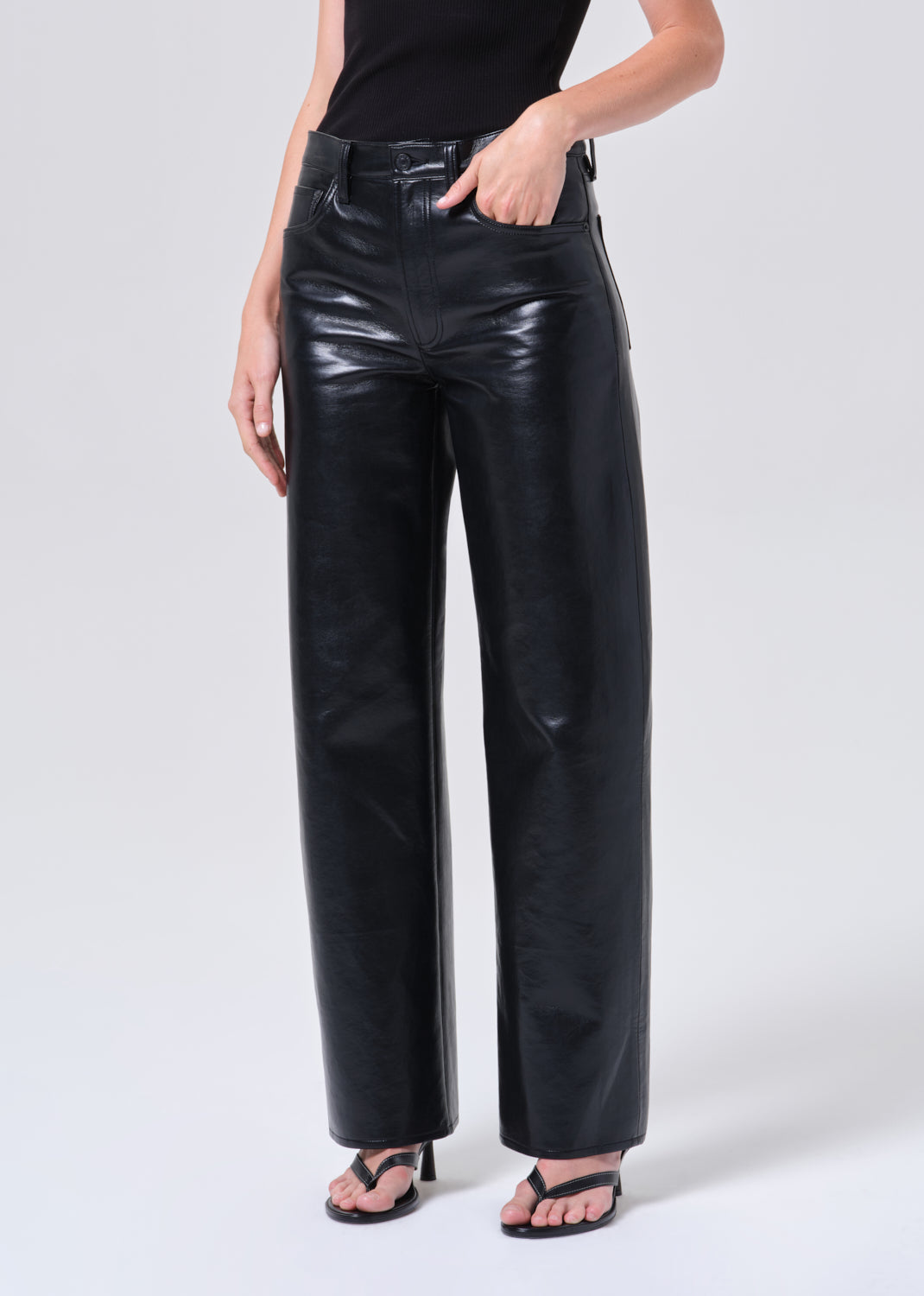 Person wearing black leather pants on a white background