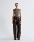 Person wearing a brown top and leather pants on a white background