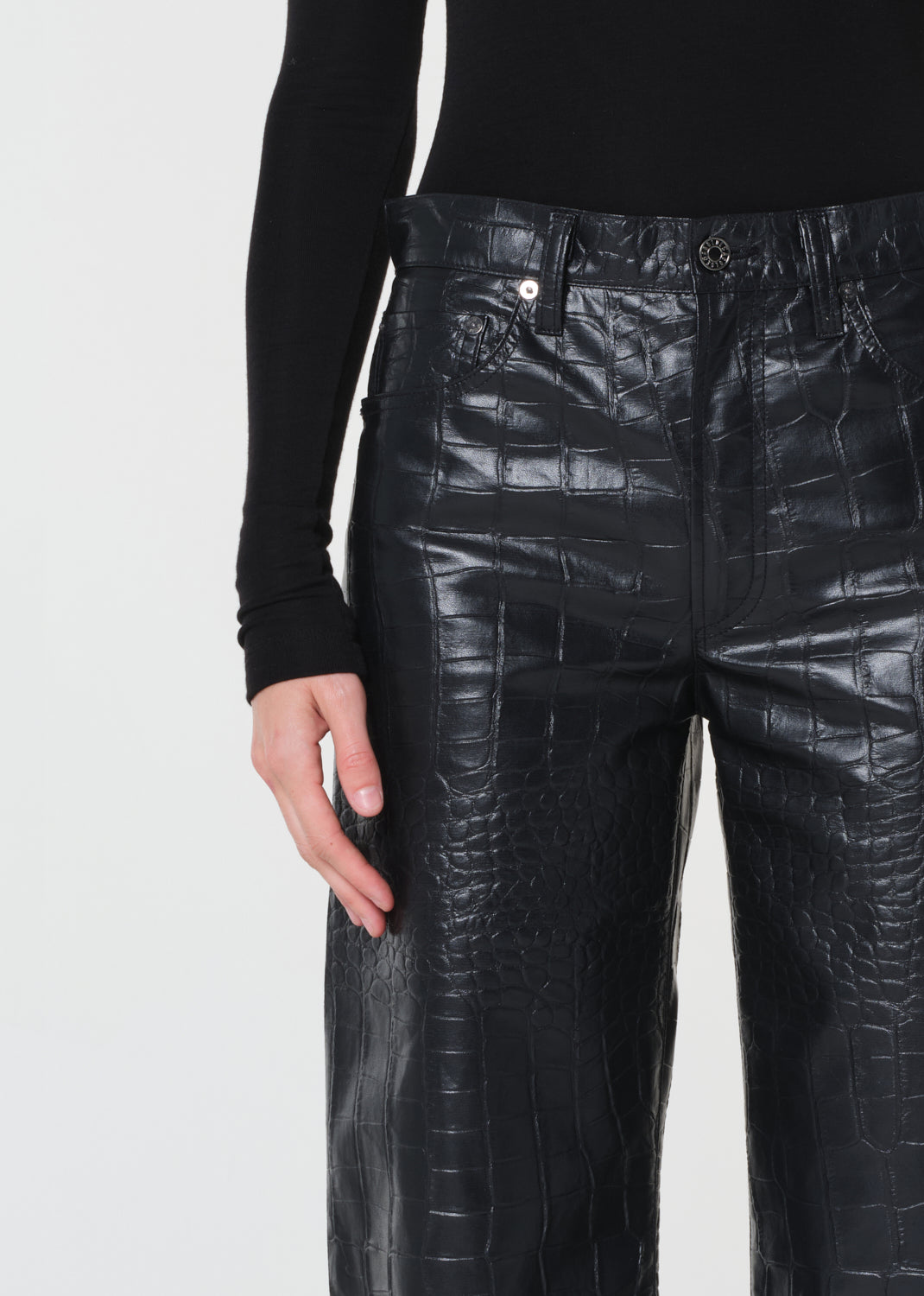 Black textured pants worn by a person on a white background