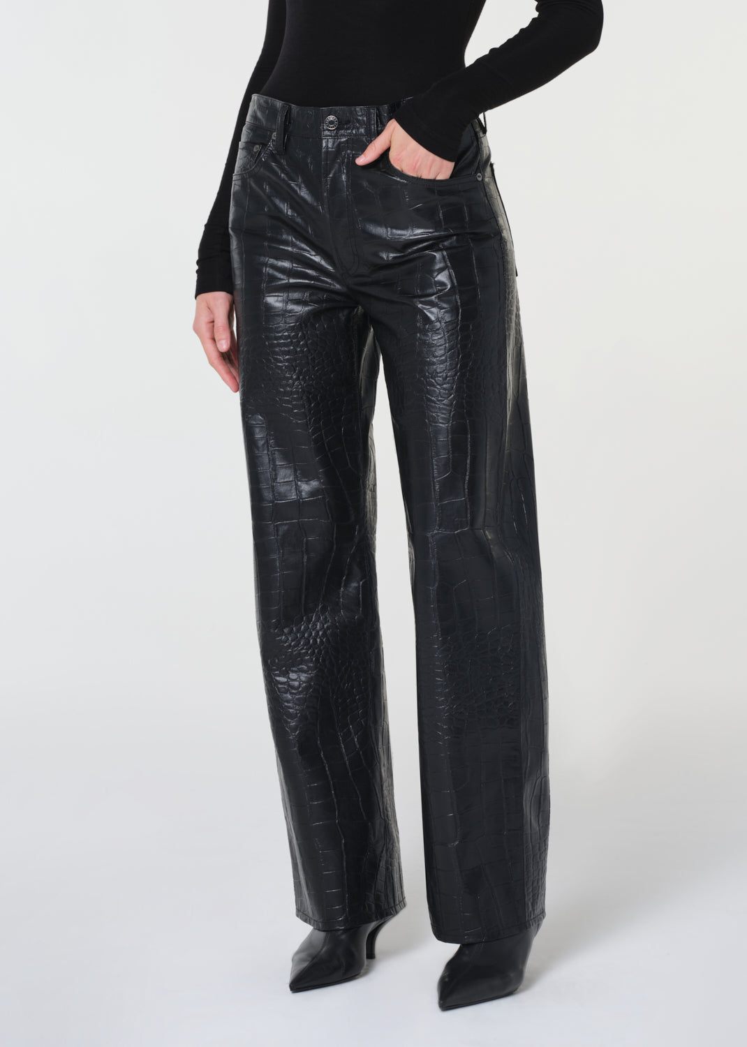 Person wearing black leather pants on a white background