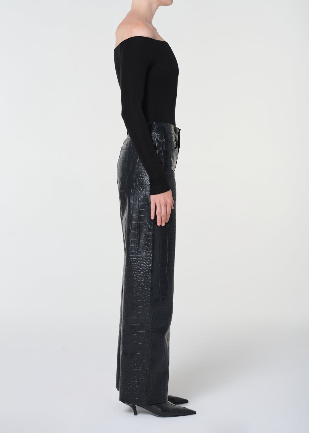 Person wearing black pants and a black top on a white background