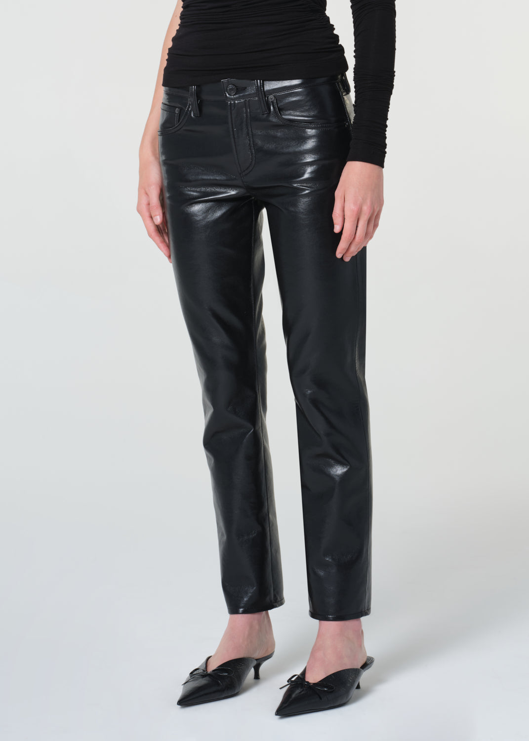 Person wearing black leather pants on a white background