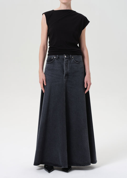 Person wearing a black top and wide-leg jeans on a white background