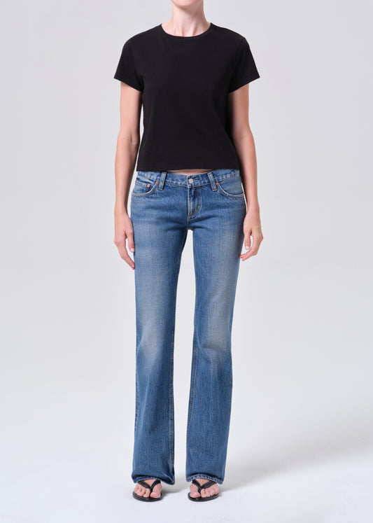 Person wearing a black t-shirt and blue jeans on a white background