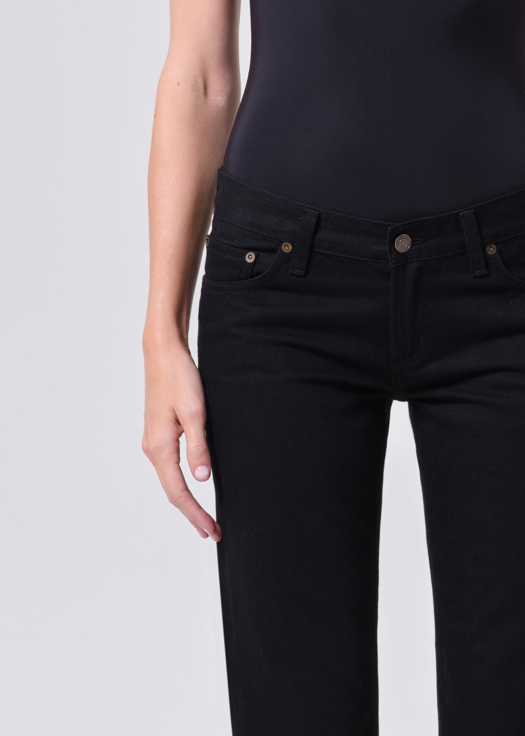 Person wearing black jeans on a white background