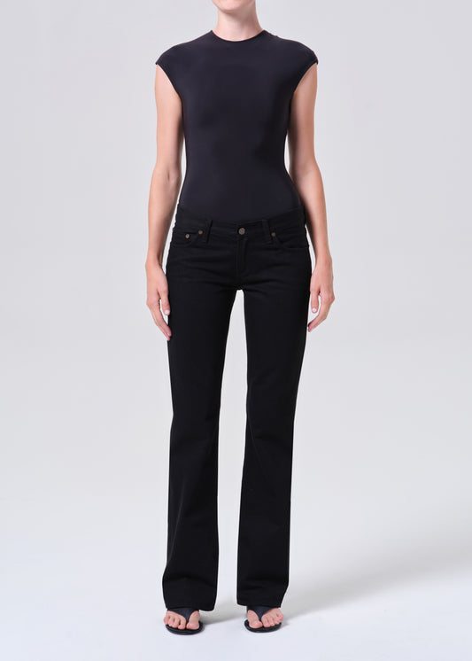 Person wearing a black sleeveless top and black pants on a white background