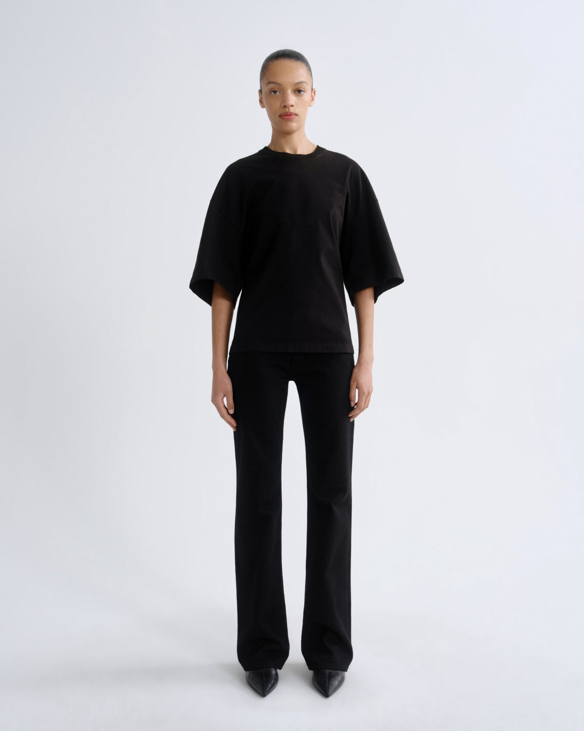 Person wearing a black outfit on a white background