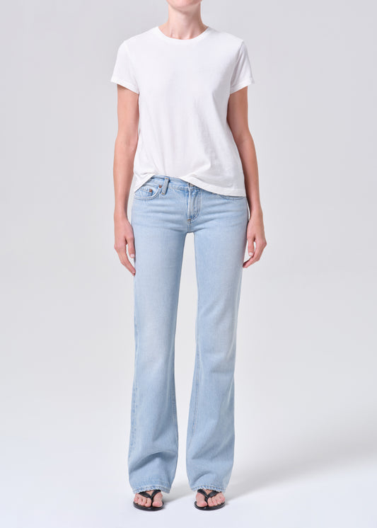 Person wearing light blue jeans and a white t-shirt on a plain background