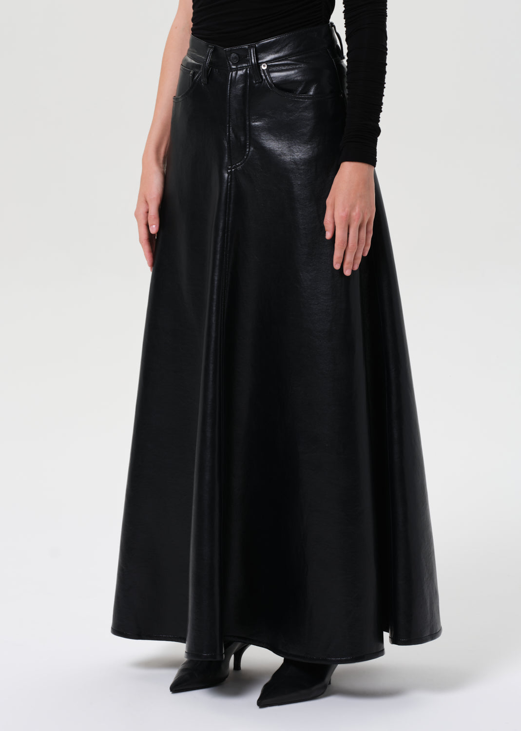 Black leather skirt worn by a person on a white background