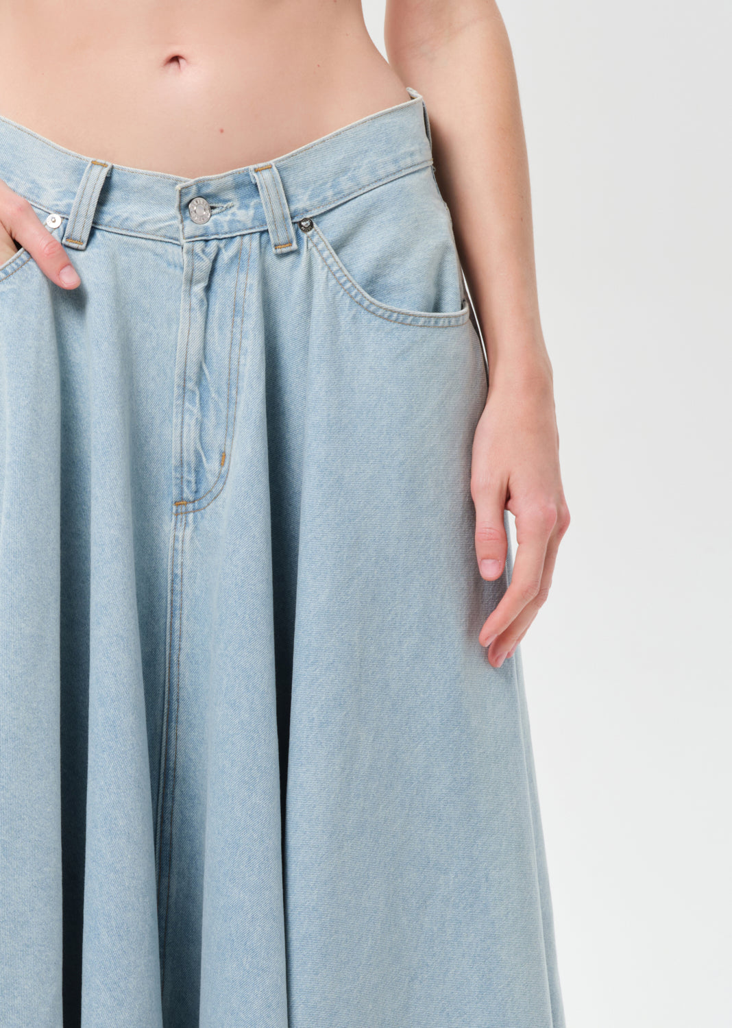 Light blue denim skirt worn by a person on a plain background