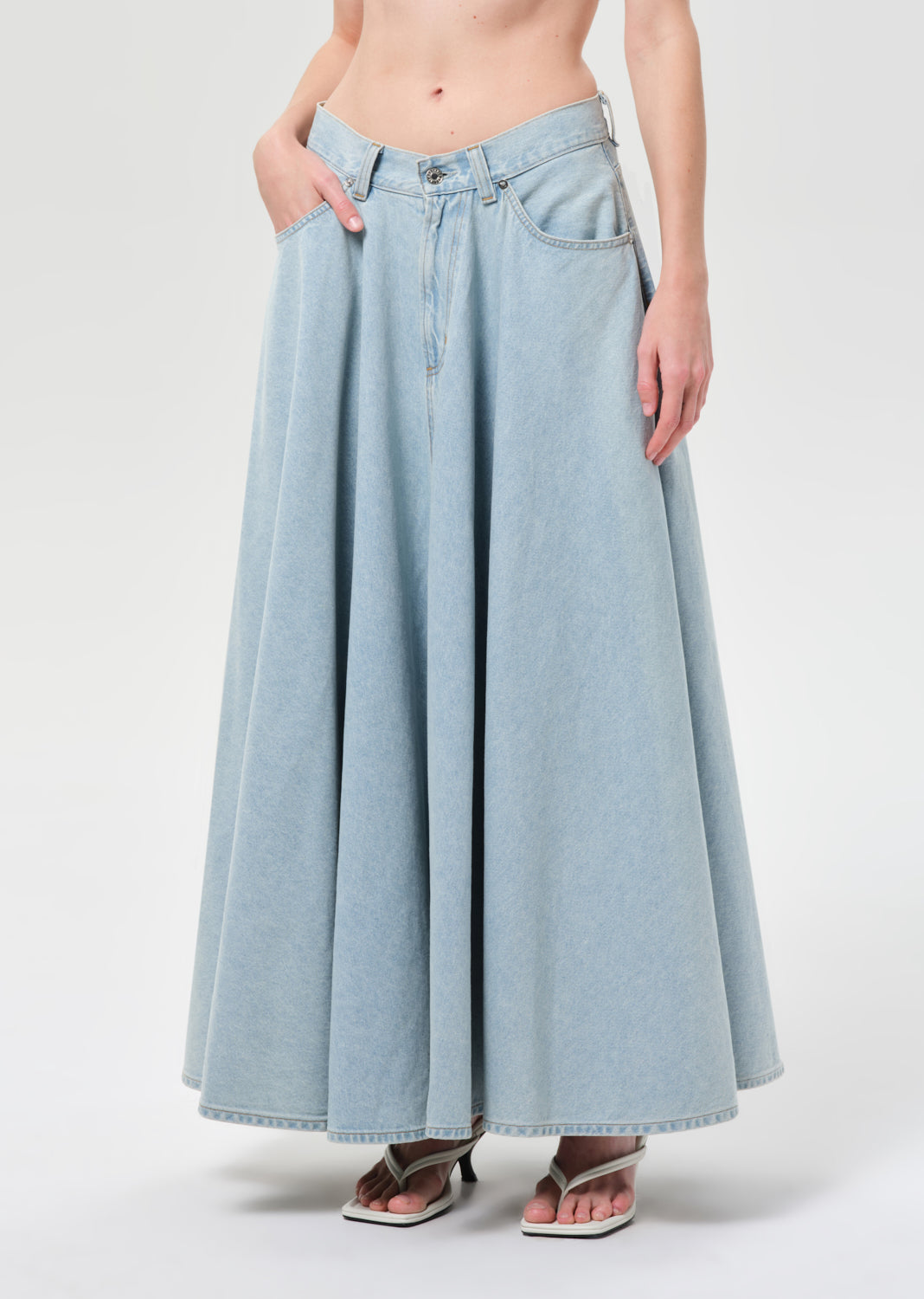 Light blue denim skirt worn by a person on a white background