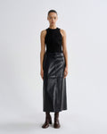 Person wearing a black sleeveless top and leather skirt on a white background
