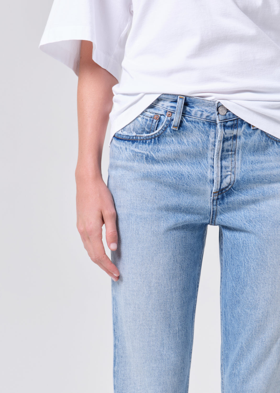 Light blue jeans worn by a person on a plain background