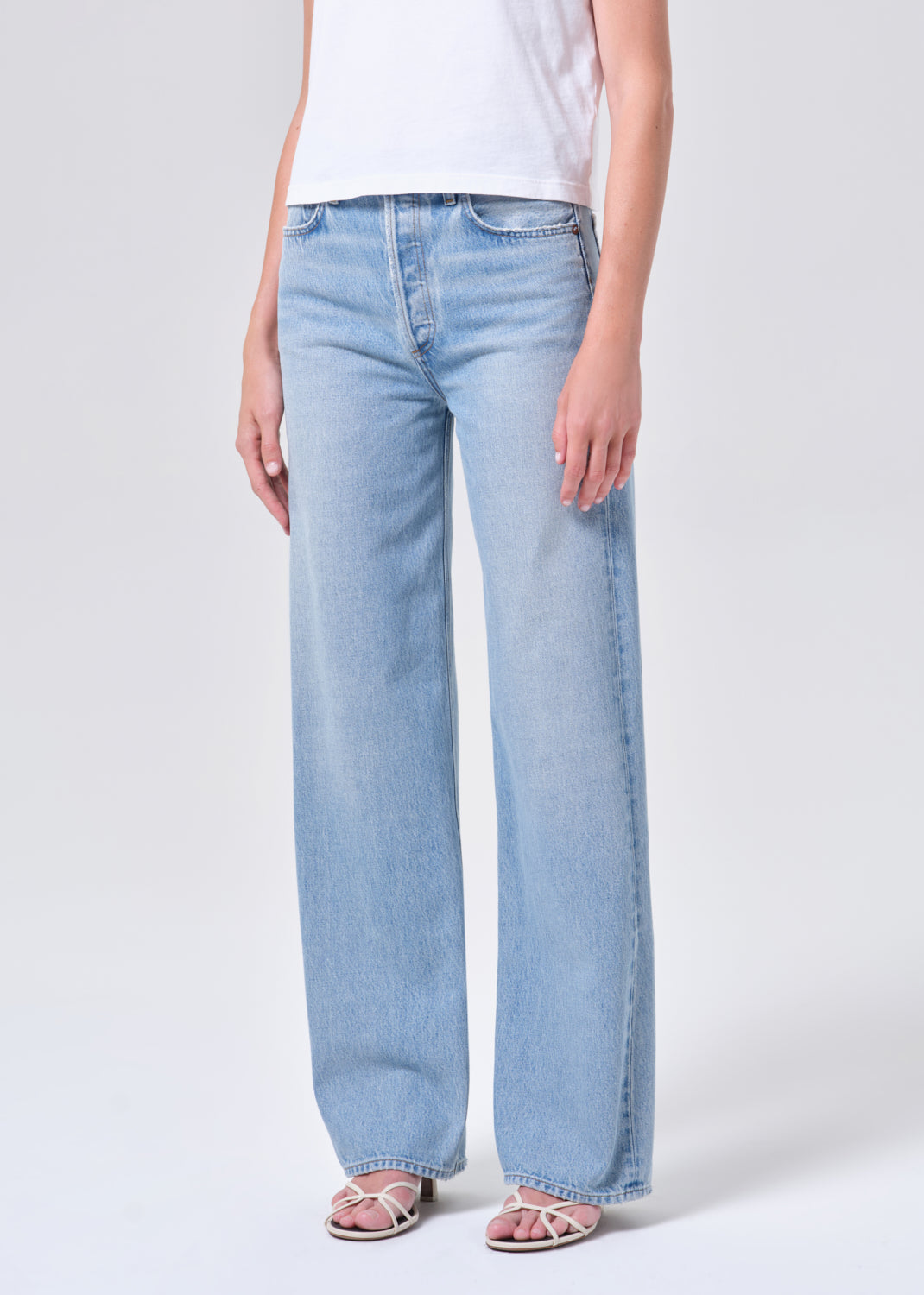 Light blue jeans worn by a person on a white background