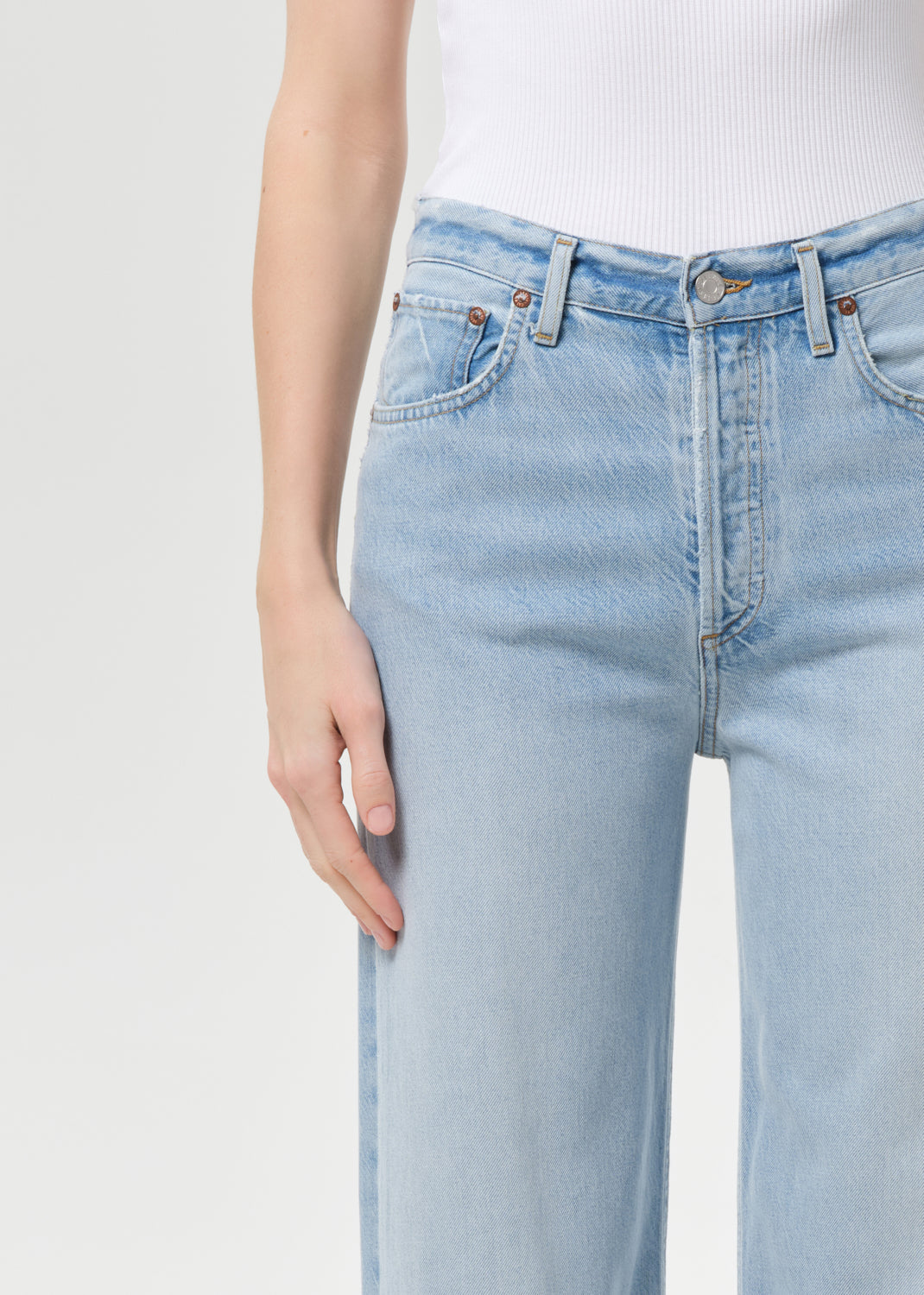 Light blue jeans worn by a person on a white background