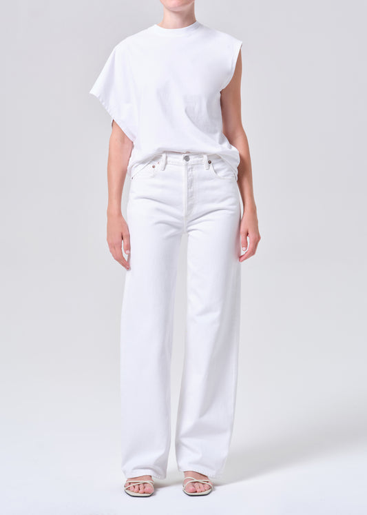 Person wearing a white t-shirt and white jeans on a plain background