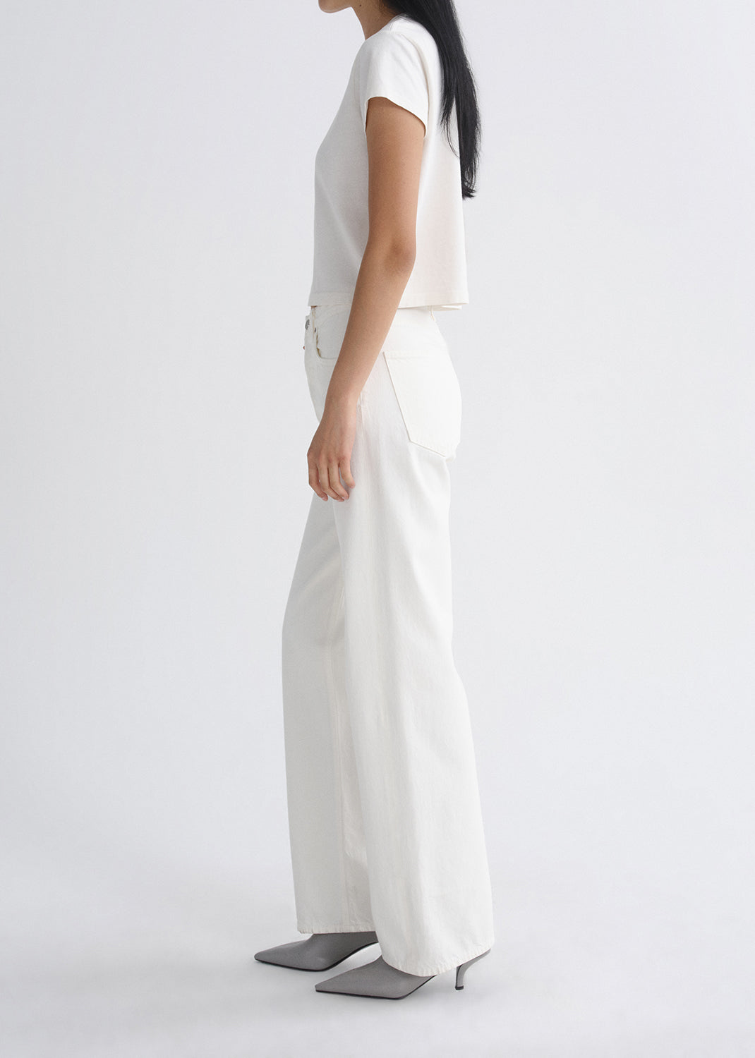 Person wearing a white outfit on a grey background
