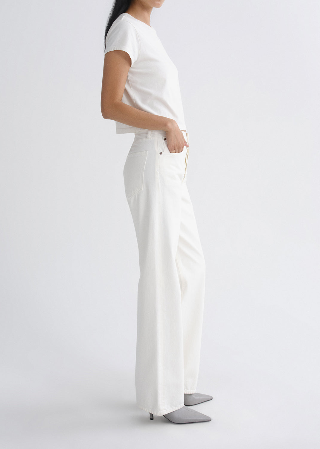 Person wearing a white outfit on a grey background