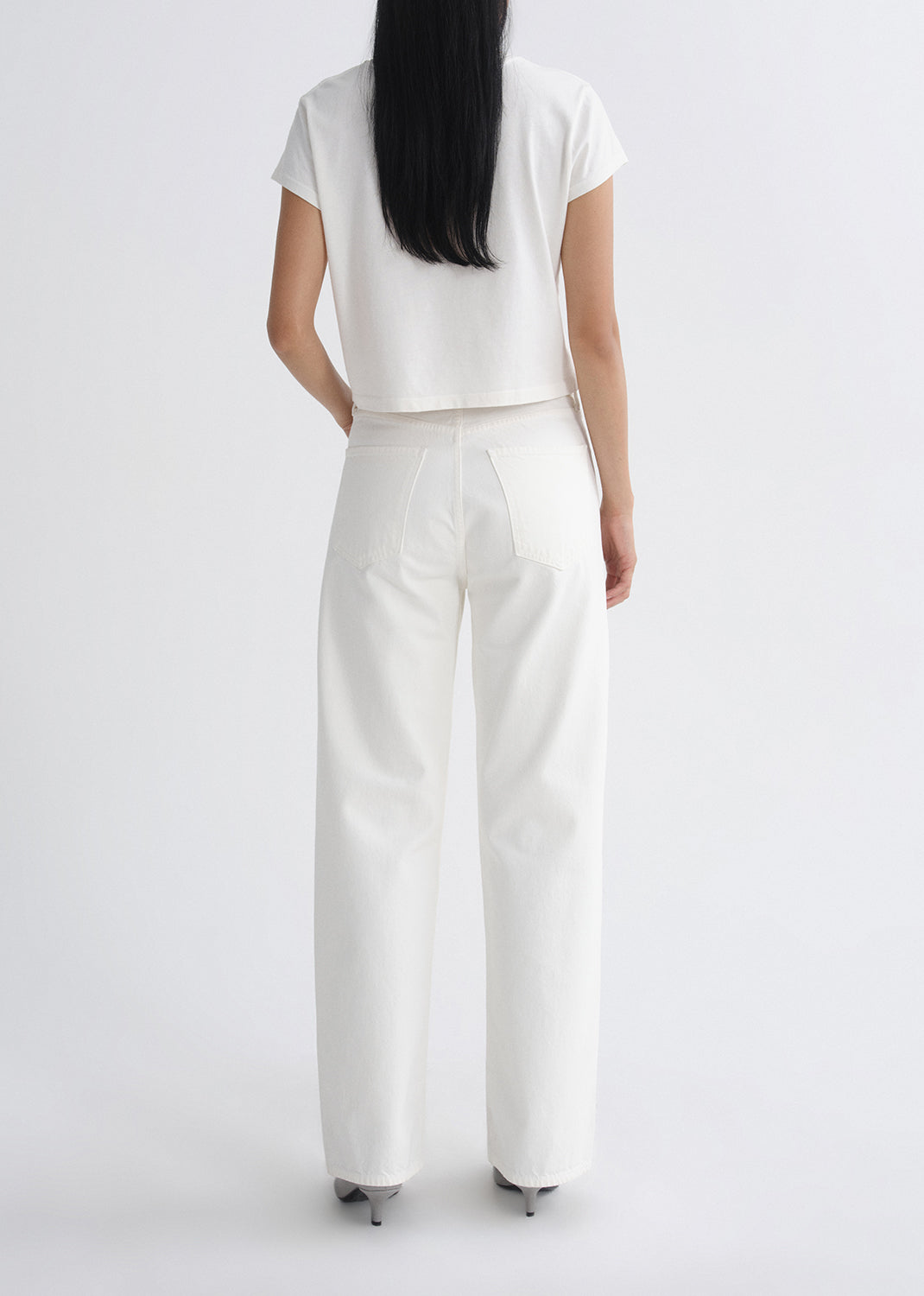 Person wearing a white outfit on a grey background