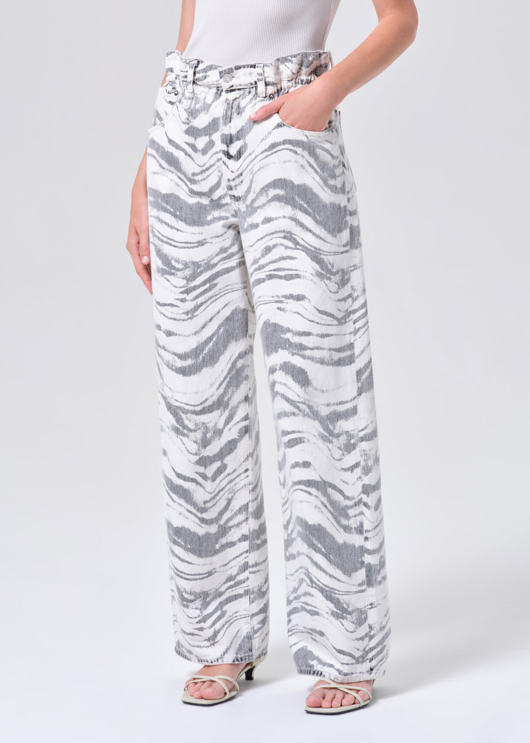 Person wearing white and gray zebra print pants on a light gray background