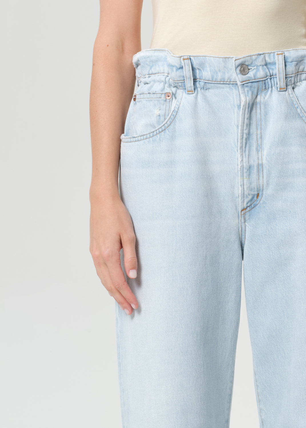 Light blue jeans worn by a person on a plain background