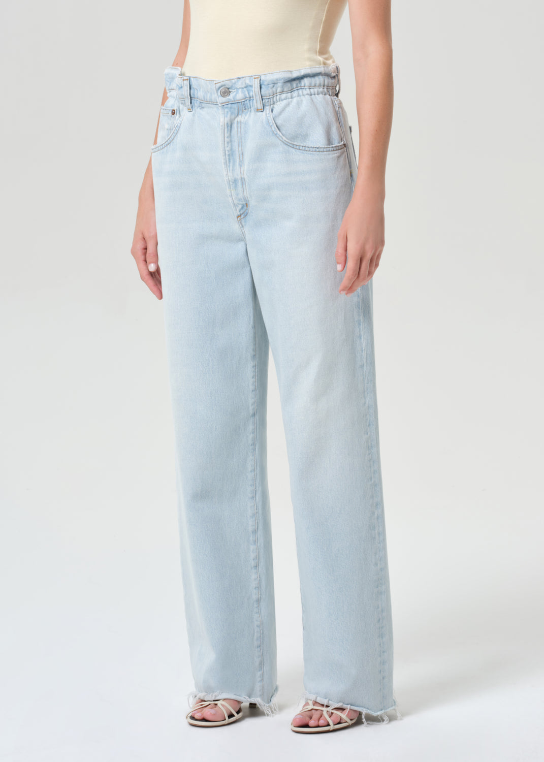 Light blue jeans worn by a person on a white background