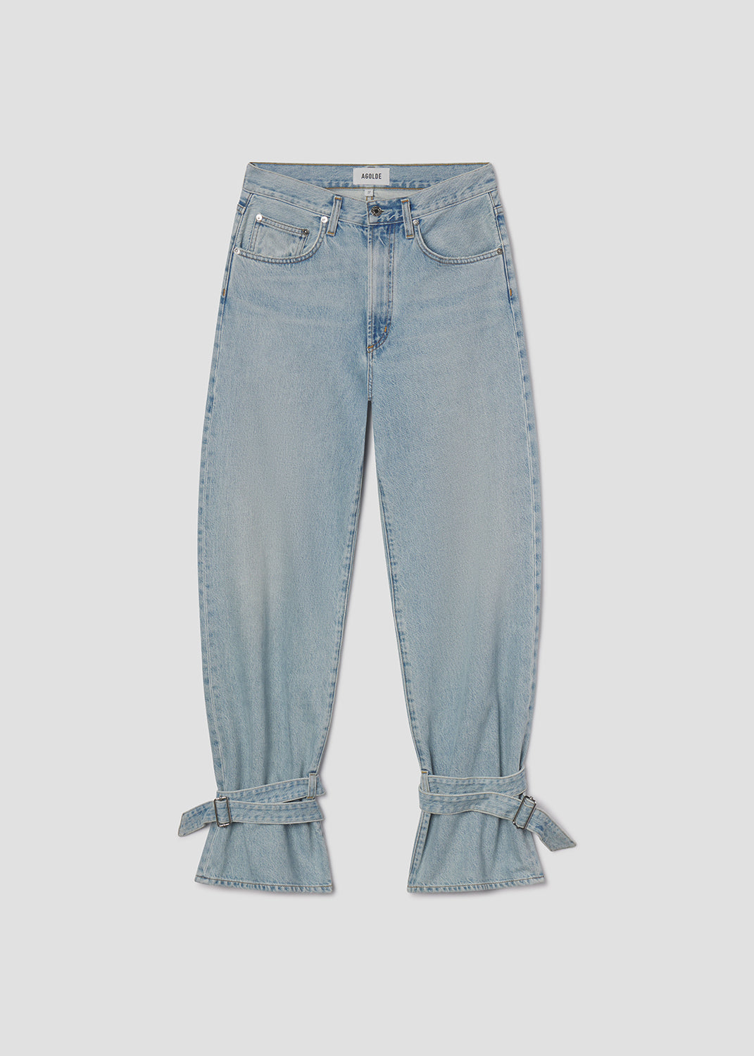 Light blue jeans with tied cuffs on a light gray background