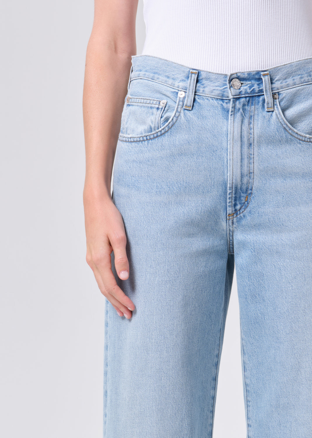 Light blue jeans worn by a person on a plain background