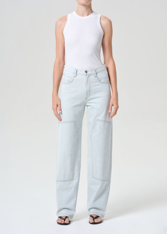Person wearing light blue jeans and a white top on a white background