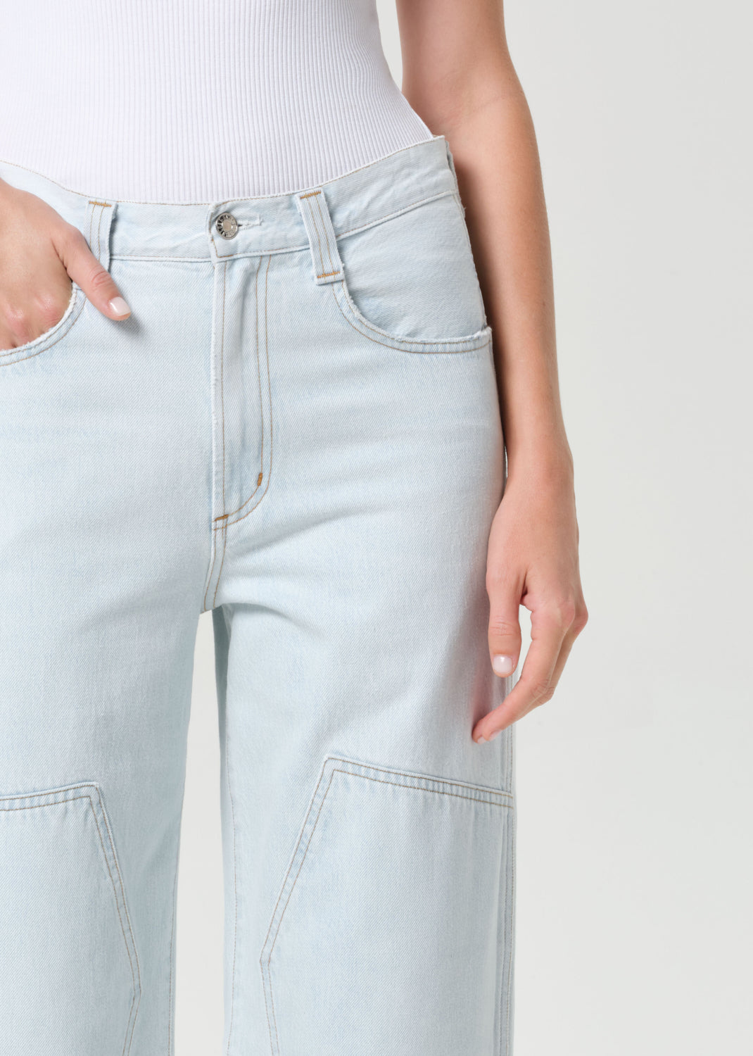 Light blue jeans worn by a person on a white background