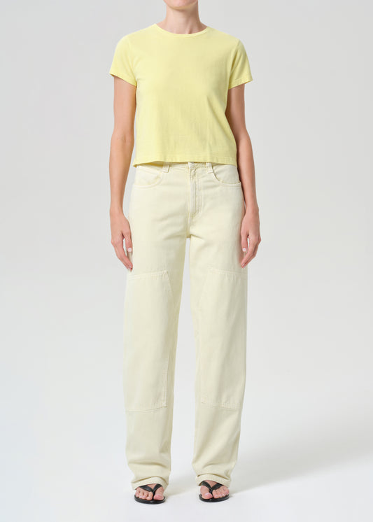 Person wearing a yellow t-shirt and light-colored pants on a white background