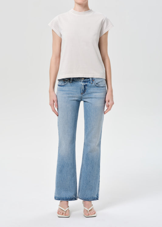 Person wearing light blue jeans and a white t-shirt on a white background