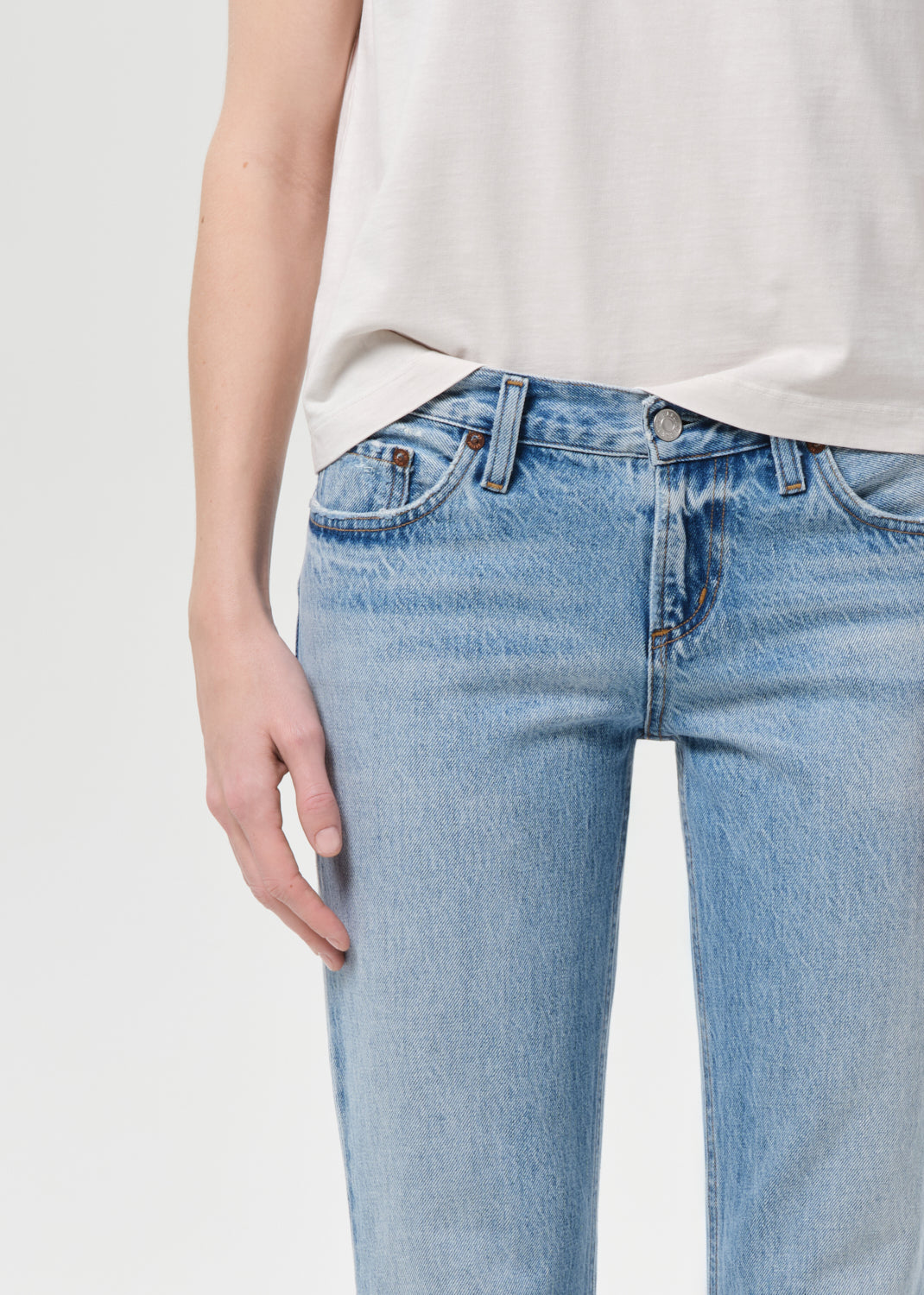 Light blue jeans worn by a person on a plain background