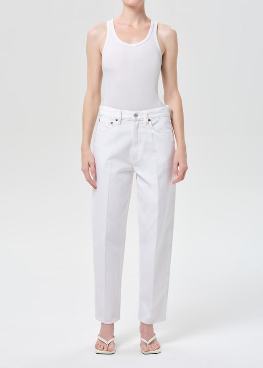 Person wearing a white tank top and white jeans on a white background