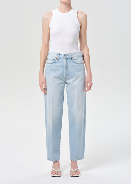 Person wearing light blue jeans and a white sleeveless top on a white background