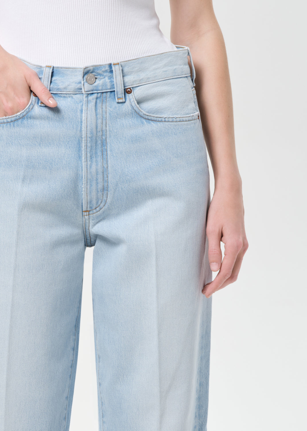 Light blue jeans worn by a person on a white background