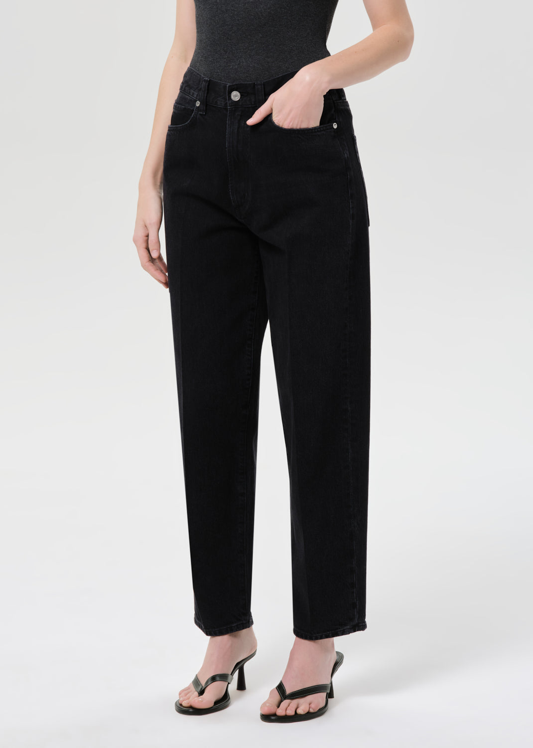 Person wearing black jeans on a white background