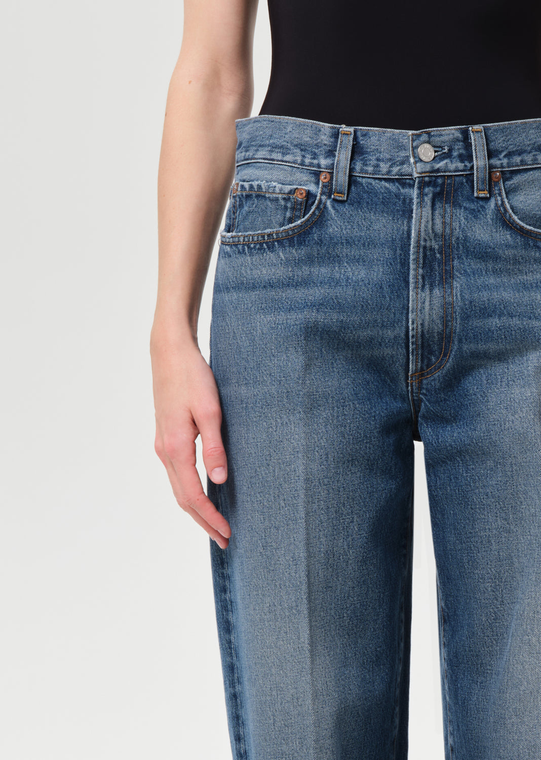 Blue jeans worn by a person on a light gray background