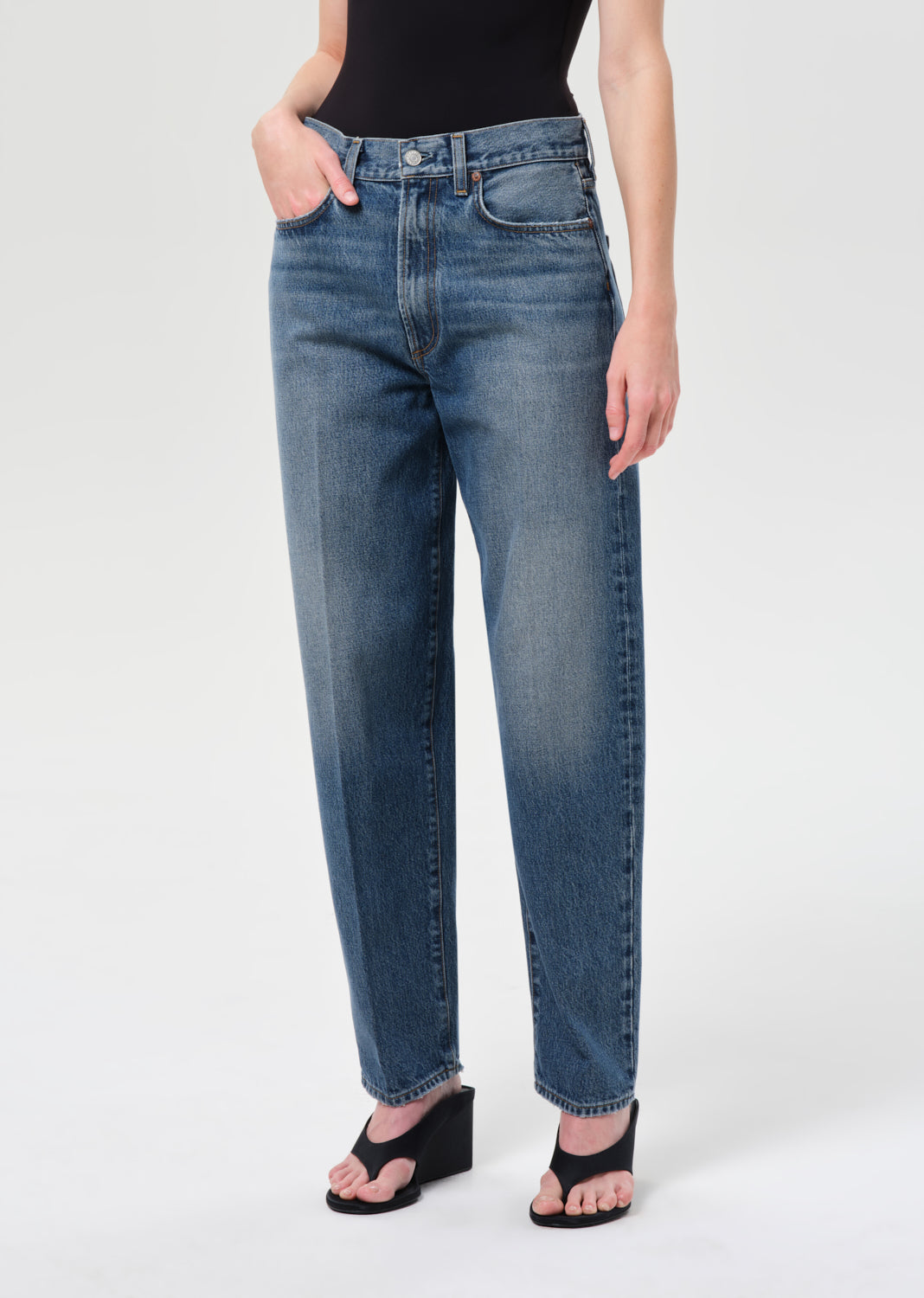 Person wearing blue jeans on a white background