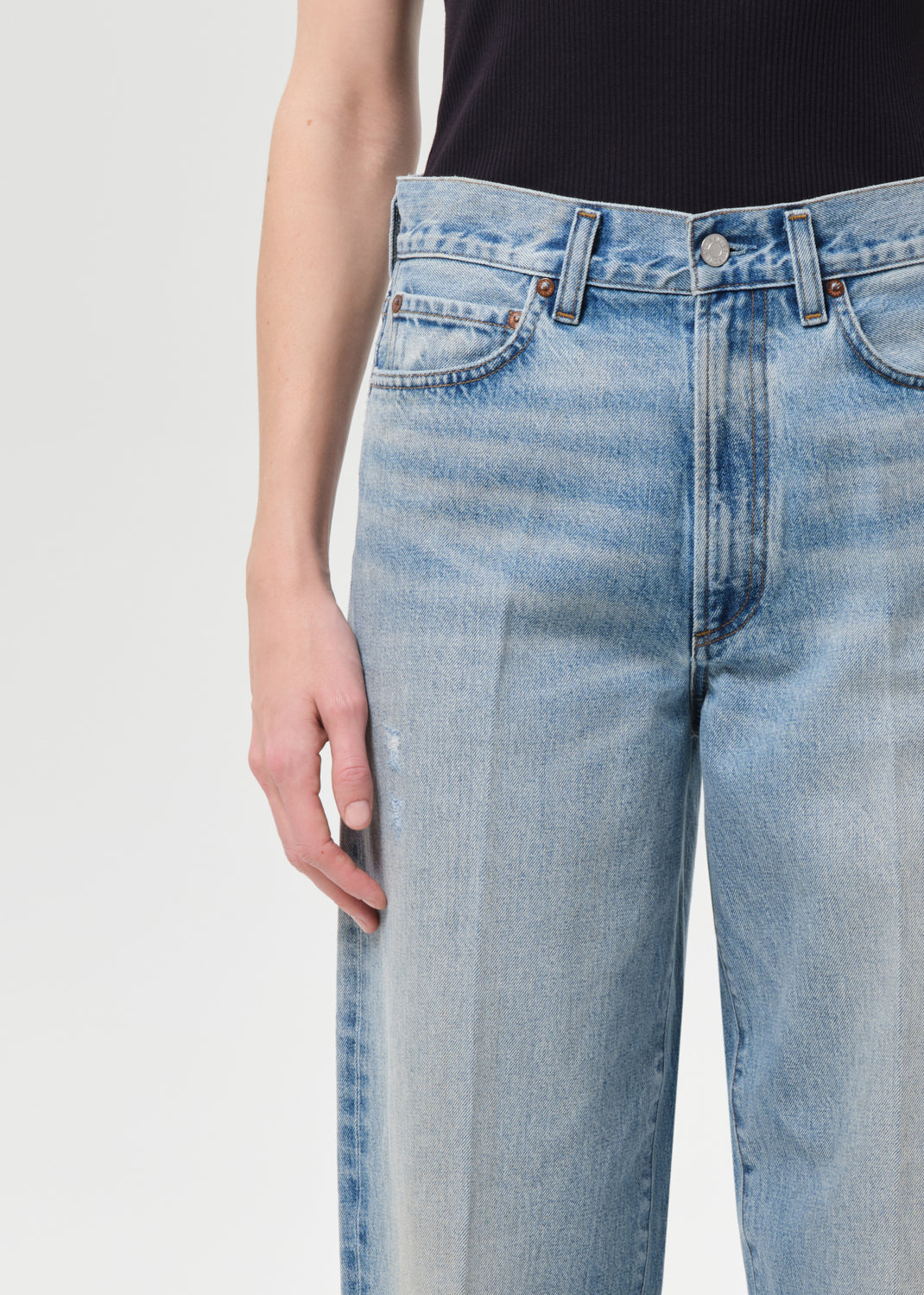 Light blue jeans worn by a person on a white background
