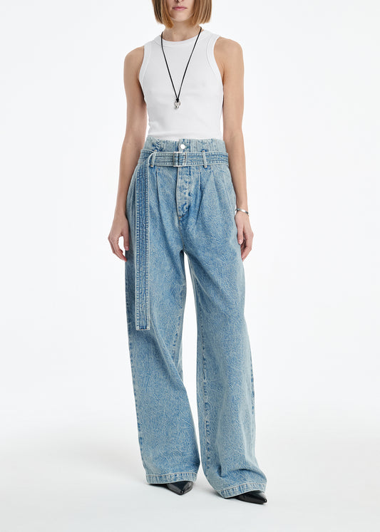 Person wearing a white sleeveless top and light blue jeans on a white background