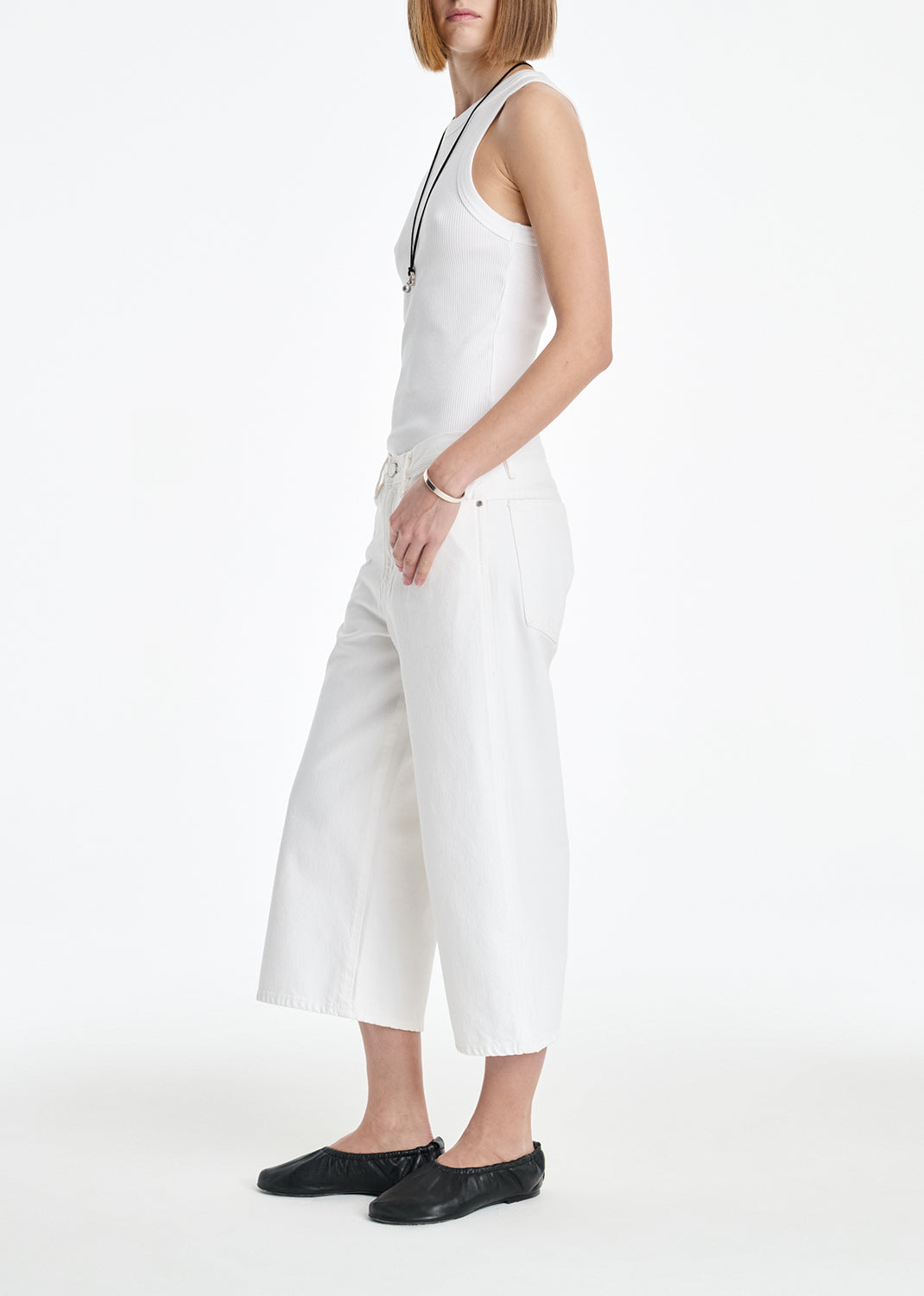 Person wearing a white sleeveless jumpsuit on a white background